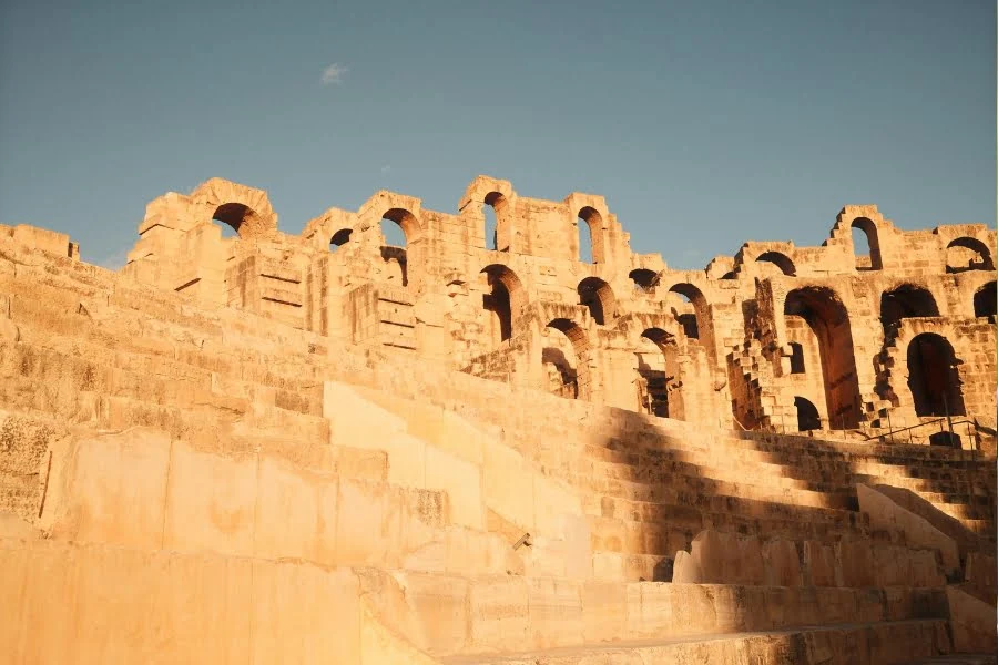 Tunesien entdecken: Aktuelle Trends, Sehenswürdigkeiten und kulinarische Highlights 15 Ihr seht ein antikes Amphitheater aus Stein mit vielen Bögen und Sitzreihen in Tunesien.