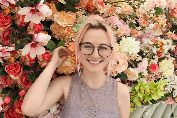 Eine junge Dame vor Blumen | Rabatte Coupons
