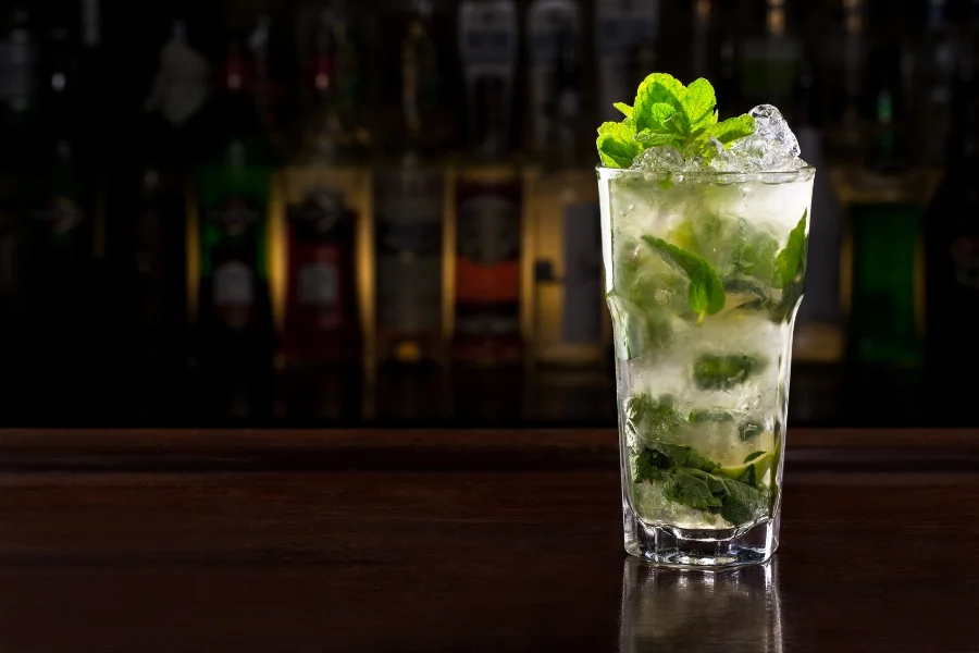 Frischer Mojito mit Minze, Limette und Crushed Ice in einer Cocktailbar.