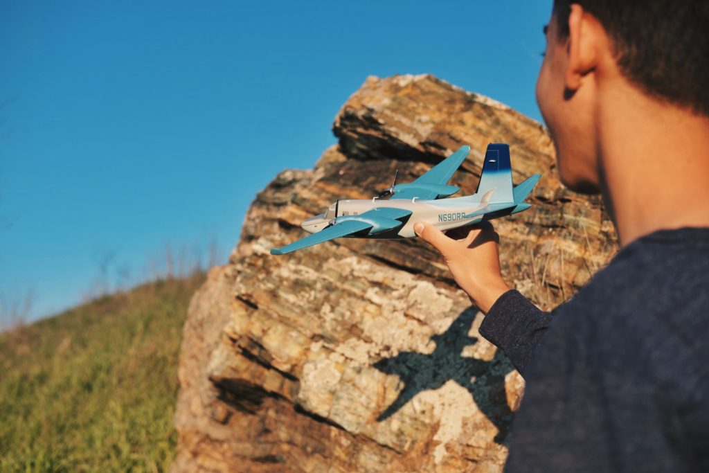 Ein Kind mit einem Spielzeugflugzeug in der Hand | Rabattcoupon