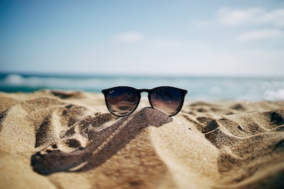 Rabatte Coupons Eine Sonnenbrille liegt auf dem Sand | Marc O'Polo Gutschein