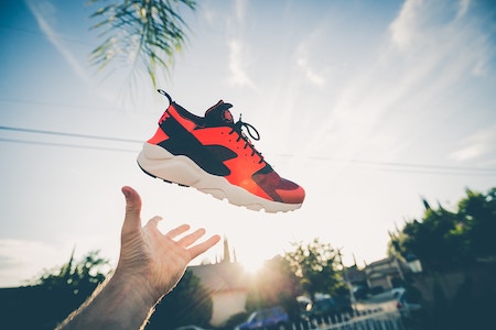 Ein roter Turnschuh wird in die Luft geworfen | rabattcoupons