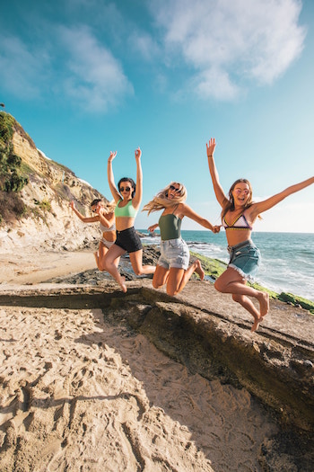 Ein paar Freundinnen beim Feiern am Strand | Rabattcoupons