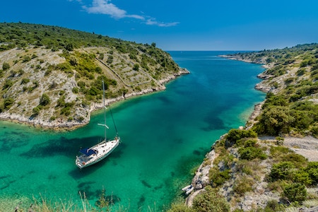Ein Boot in einer türkisblauen Bucht | Rabatte Coupons