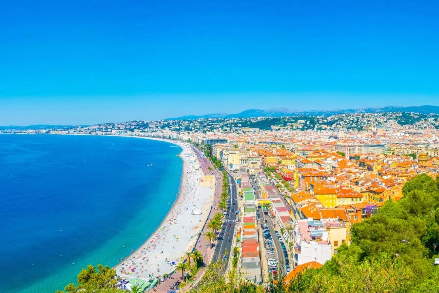 Frankreich erleben: Tolle Ziele außerhalb von Paris 4 Panoramablick auf die Promenade des Anglais und den Strand von Nizza an der französischen Côte d'Azur bei sonnigem Wetter.