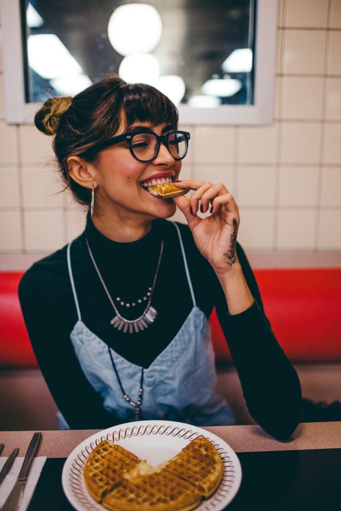 Frau beißt in Waffel.
