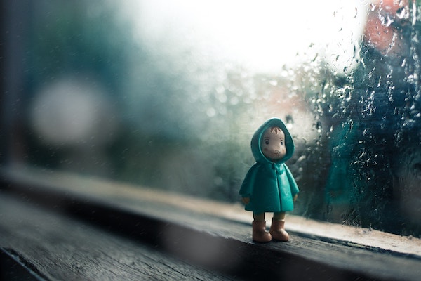 Eine Puppe vor dem verregneten Fenster