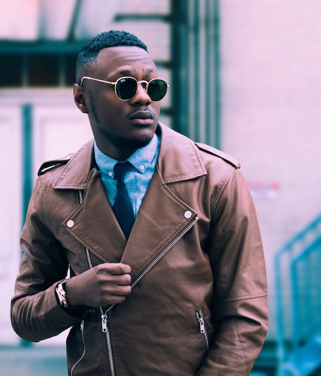 Ein Mann mit einer Sonnenbrille und einer braunen Lederjacke | Rabatte Coupons