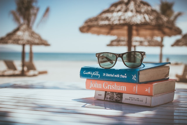 Eine Sonnenbrille auf einem Bücherstapel | rabatte coupons 