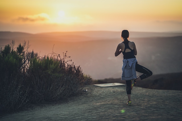 Eine Frau im Sonnenuntergang beim Yoga | rabatte coupons