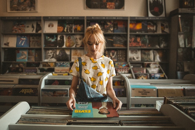 Ein Mädchen hält eine Elvis Vinylplatte | rabatte coupons