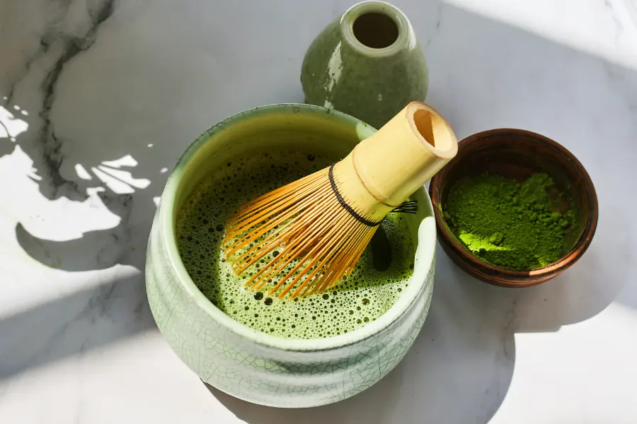 Tolle Trinkflaschen für Teesorten und ihre Wirkung zu tollen Preisen mit dem Gutschein klean kanteen | www.rabatt-coupon.com Frisch zubereiteter Matcha-Tee in einer grünen Schale mit Bambusbesen und feinem Matcha-Pulver.