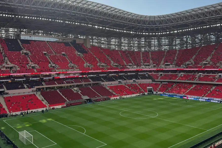 Fussball Vereine haben finanziell zu kämpfen, davon ist kein ausgeschlossen. Dennoch könnt ihr mit dem FC Bayern Fan-Shop Gutschein von vielen Rabatten profitieren. Large modern soccer stadium with red seating, a green pitch, and a partially covered roof.