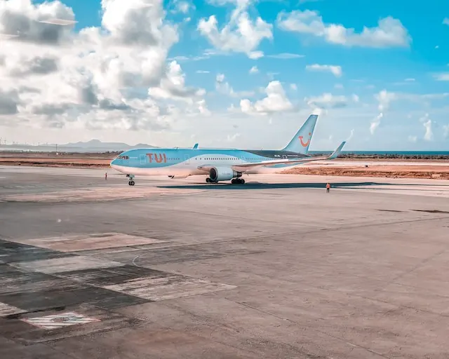 TUI-Flugzeug auf dem Rollfeld bei sonnigem Wetter mit Meerblick im Hintergrund