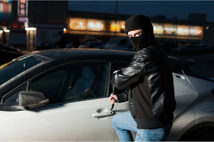 Schutz gegen Diebstahl: Wie sicher sind Schlösser, Autos und eure Daten wirklich? 2 Maskierter Mann versucht nachts, die Tür eines geparkten Autos zu öffnen.