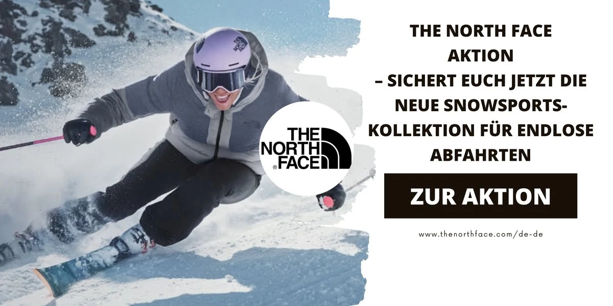 Eine Skifahrerin in grauer Skibekleidung von The North Face fährt rasant eine schneebedeckte Piste hinunter. Im Vordergrund fliegt der Schnee auf.