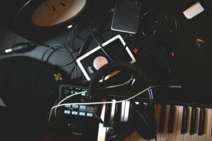 Ein Tisch mit Kopfhörer, Kabel und Instrumenten und einem Piano