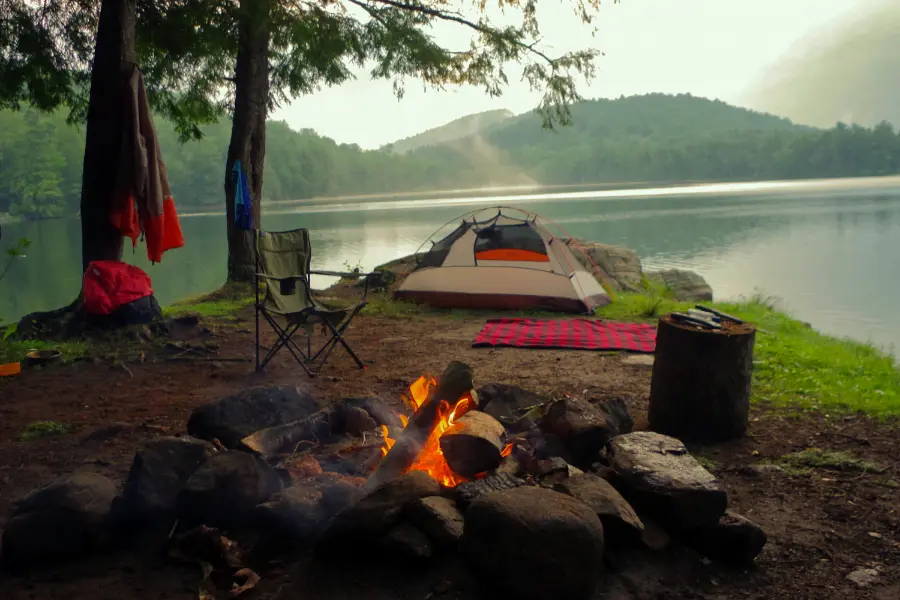 campingzelt am see in der dämmerung mit Lagerfeuer