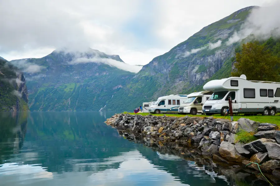 camping wagen an einem ufer in einem bergtal