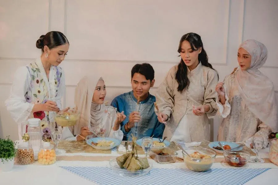 Gruppe sitzt gemeinsam am Tisch mit traditionellen Speisen bei einem festlichen Abendessen