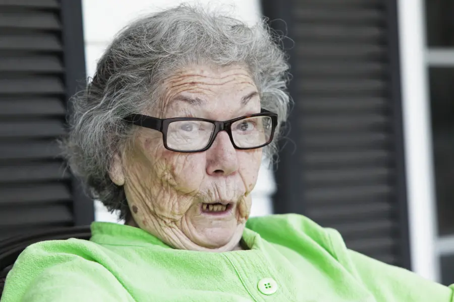 Balkon oder Garten – So gestaltet ihr euer privates Paradies 3 Ältere Frau mit Brille und überraschter Mimik sitzt draußen und schaut erstaunt nach vorne.